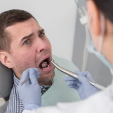Dentist examining man's wisdom teeth in Sydney clinic