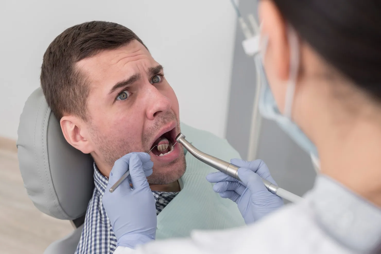 Dentist examining man's wisdom teeth in Sydney clinic