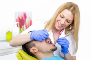 Young female dentist treating male patient for wisdom teeth in Sydney