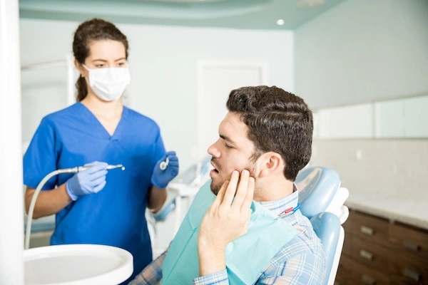 Patient with jaw pain discusses wisdom teeth removal with a dentist at Pinho Dental in Sydney